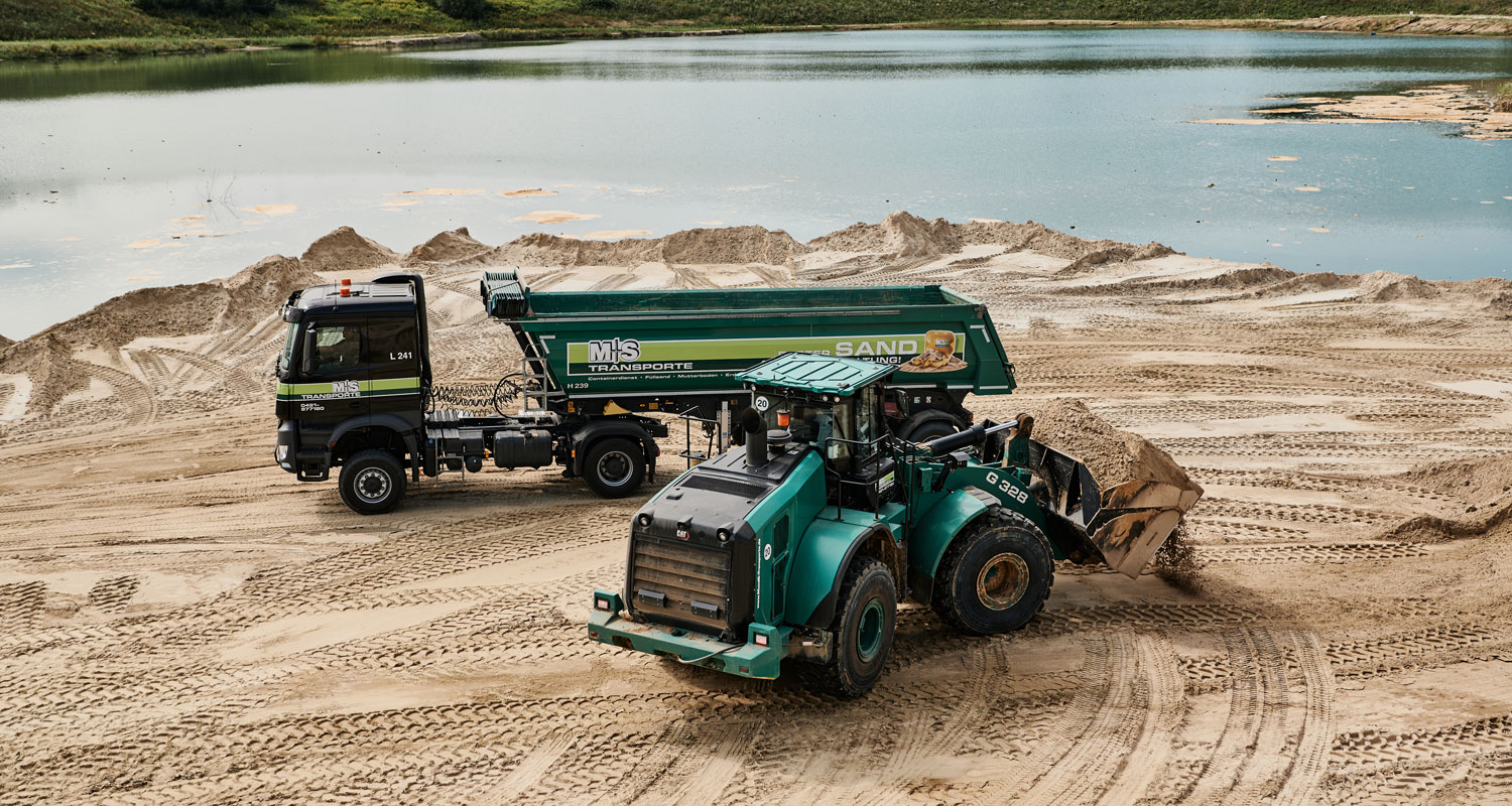 Bagger befühlt Container mit Sand, Sigrun Strangmann Photography